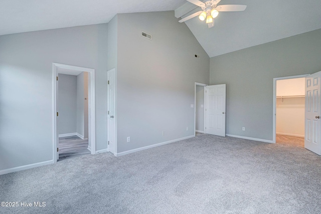 unfurnished bedroom with high vaulted ceiling, carpet floors, a spacious closet, baseboards, and beamed ceiling