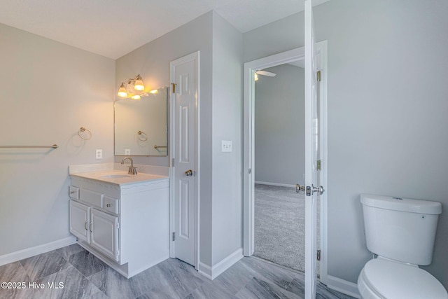 bathroom featuring vanity, baseboards, and toilet