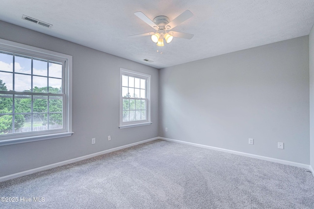 empty room featuring baseboards, a ceiling fan, carpet, and a textured ceiling