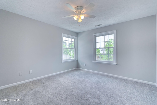 unfurnished room with a textured ceiling, baseboards, carpet floors, and a ceiling fan