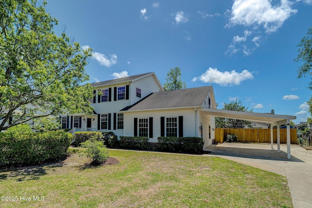 colonial home featuring driveway and a carport