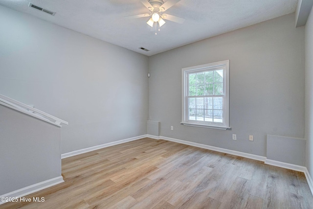 empty room with light wood-style flooring, ceiling fan, and baseboards