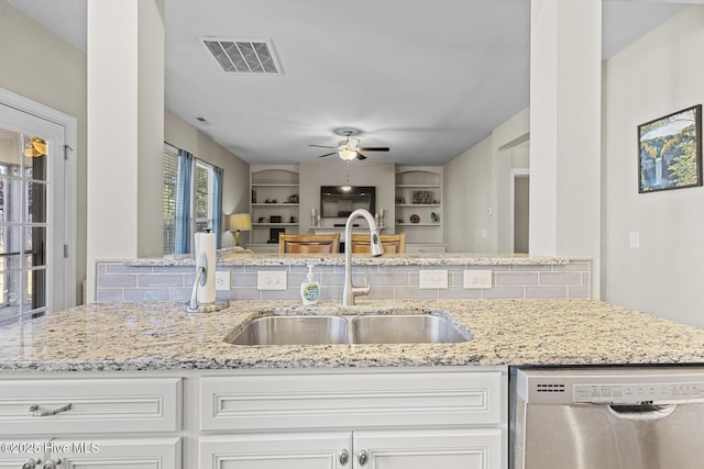 211 Willow Ridge Dr, Holly Ridge, NC 28445 - kitchen with stainless steel dishwasher, a sink, a ceiling fan, light stone countertops, and tasteful backsplash