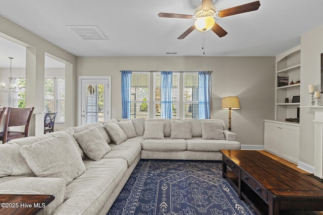 211 Willow Ridge Dr, Holly Ridge, NC 28445 - living area featuring ceiling fan, a chandelier, built in shelves, and baseboards