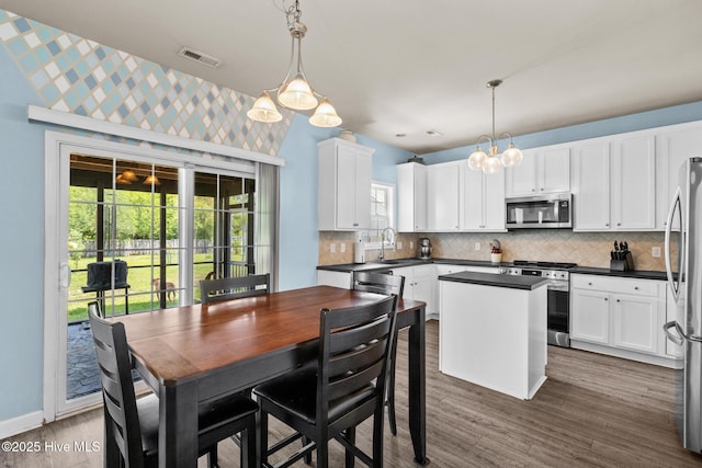 134 Inverness Dr, Hubert, NC 28539 - kitchen featuring appliances with stainless steel finishes, dark countertops, decorative backsplash, and white cabinets
