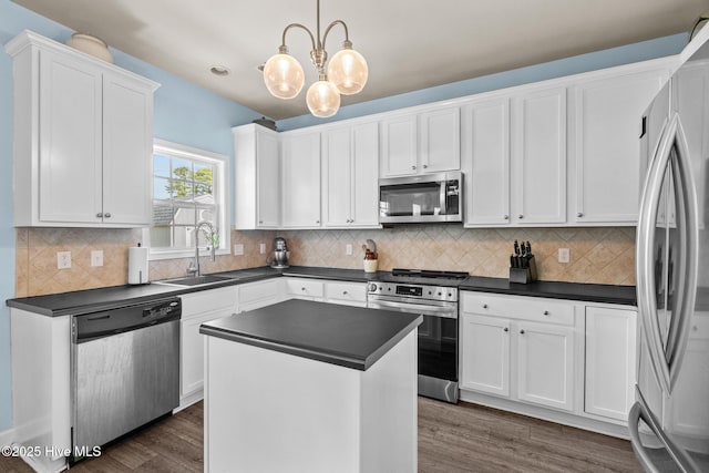 134 Inverness Dr, Hubert, NC 28539 - kitchen with stainless steel appliances, a sink, dark countertops, and white cabinetry