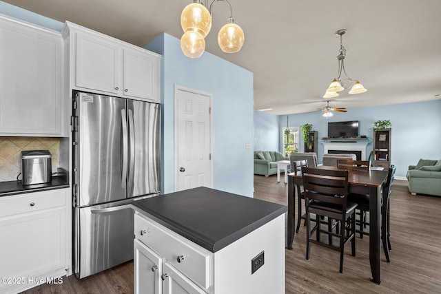 134 Inverness Dr, Hubert, NC 28539 - kitchen with freestanding refrigerator, dark countertops, a ceiling fan, open floor plan, and dark wood-style flooring