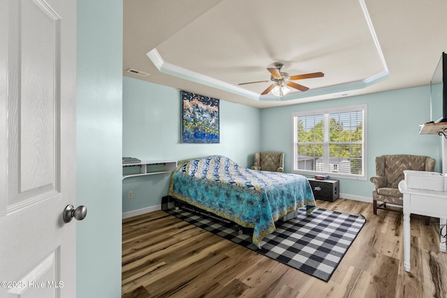 134 Inverness Dr, Hubert, NC 28539 - bedroom featuring a tray ceiling, wood finished floors, baseboards, and a ceiling fan