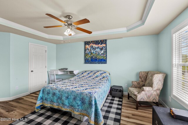134 Inverness Dr, Hubert, NC 28539 - bedroom featuring a tray ceiling, ornamental molding, wood finished floors, multiple windows, and baseboards