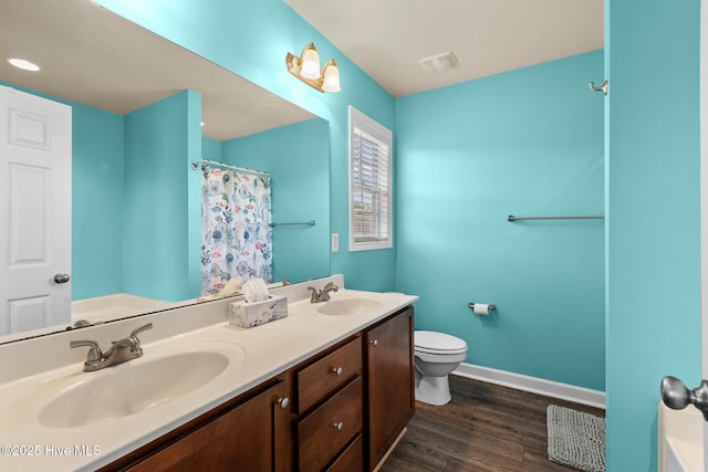 134 Inverness Dr, Hubert, NC 28539 - bathroom with wood finished floors, toilet, baseboards, double vanity, and curtained shower
