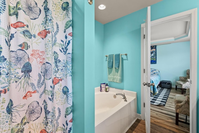 134 Inverness Dr, Hubert, NC 28539 - full bath featuring connected bathroom, wood finished floors, a garden tub, baseboards, and a shower with curtain