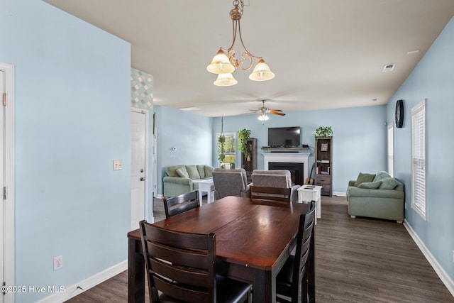 134 Inverness Dr, Hubert, NC 28539 - dining room featuring ceiling fan, a fireplace, dark wood-style flooring, and baseboards
