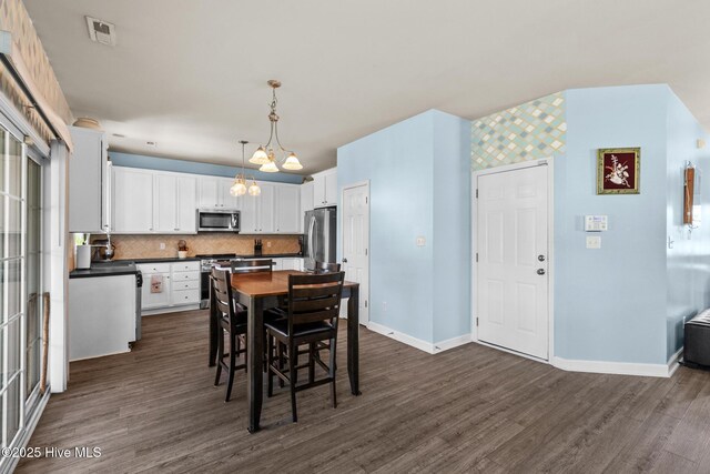 134 Inverness Dr, Hubert, NC 28539 - dining room with a chandelier, dark wood-style flooring, and baseboards