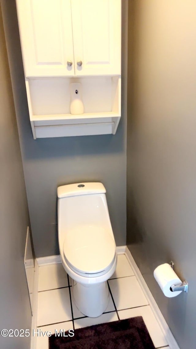 bathroom featuring tile patterned flooring, toilet, and baseboards