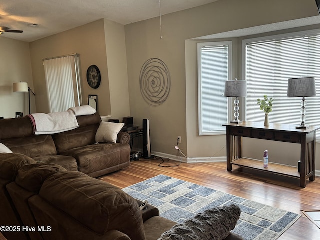 living room with wood finished floors, ceiling fan, and baseboards