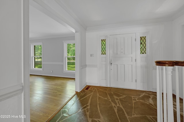 foyer featuring ornamental molding, wood finished floors, and baseboards