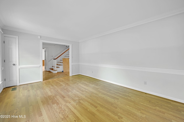unfurnished living room with stairway, light wood finished floors, ornamental molding, and baseboards