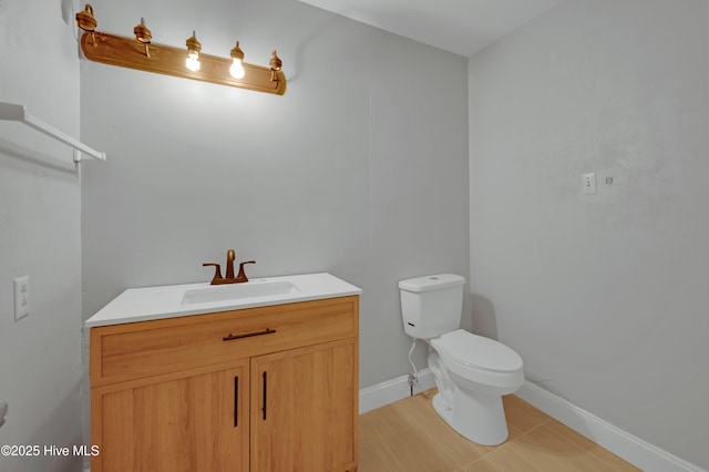 half bathroom featuring vanity, toilet, and baseboards