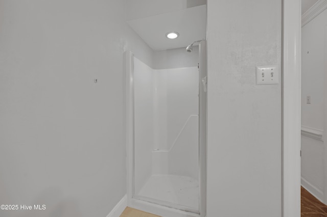 bathroom featuring a shower stall and baseboards
