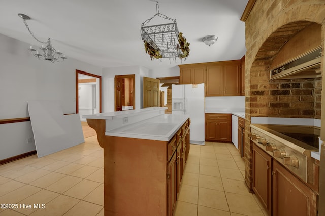 kitchen with a center island, light countertops, a chandelier, light tile patterned floors, and white fridge with ice dispenser