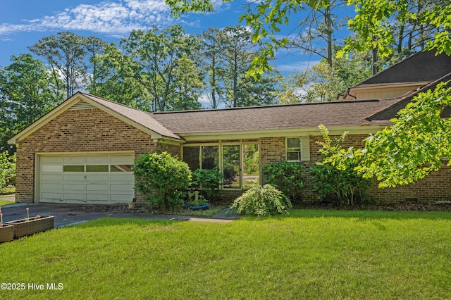 ranch-style home featuring brick siding, an attached garage, a front lawn, and driveway