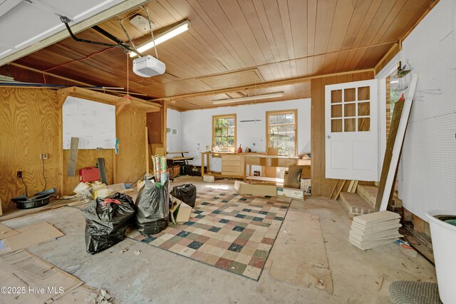misc room with wooden walls, concrete flooring, and wooden ceiling
