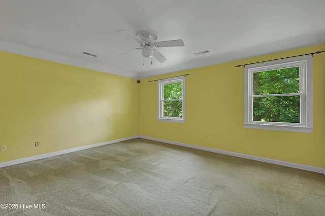 carpeted empty room with ceiling fan and baseboards