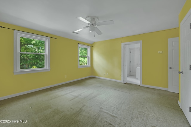 carpeted empty room with baseboards, healthy amount of natural light, and a ceiling fan