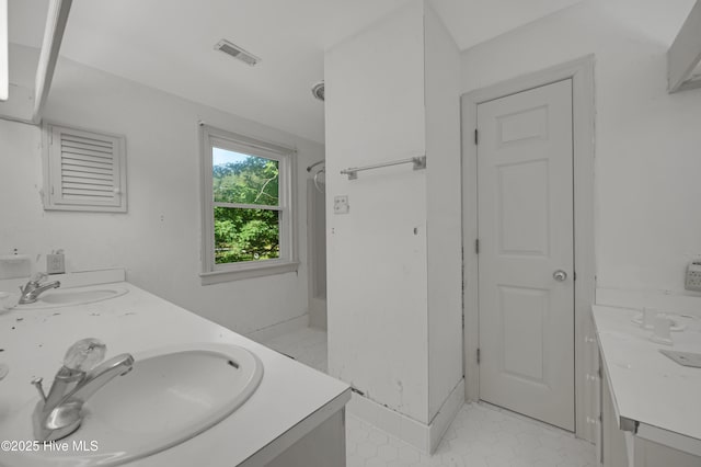full bathroom with double vanity, tile patterned flooring, and a shower