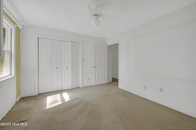 unfurnished bedroom with carpet floors, baseboards, and a closet