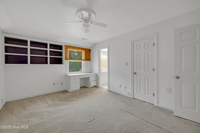 unfurnished bedroom with light carpet, baseboards, connected bathroom, and ceiling fan