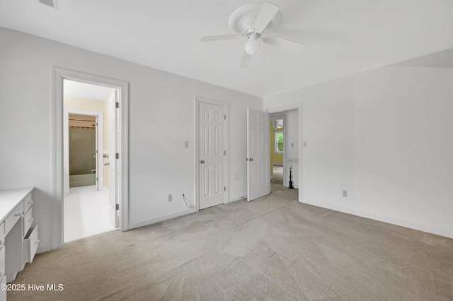 unfurnished bedroom featuring light colored carpet, baseboards, and ceiling fan