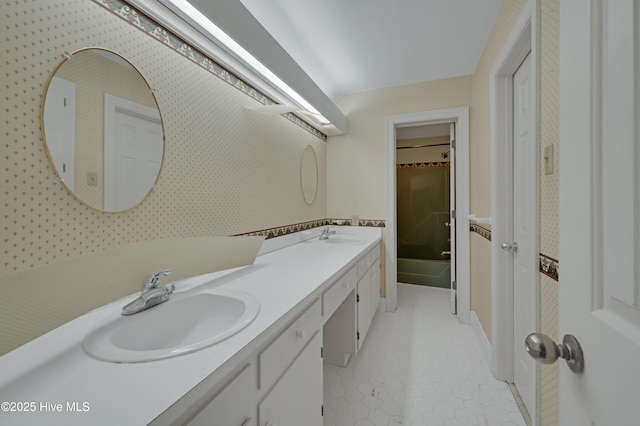 bathroom with double vanity, tile patterned flooring, wallpapered walls, and a bath