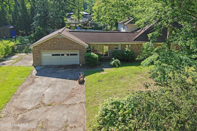 view of front facade with concrete driveway, brick siding, a front yard, and an attached garage