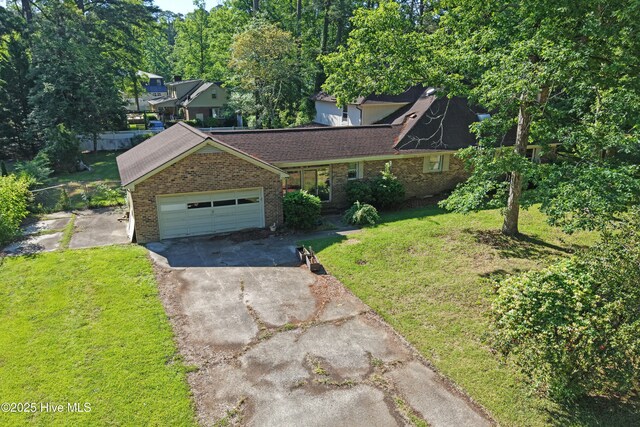 view of front facade with driveway, brick siding, an attached garage, and a front yard