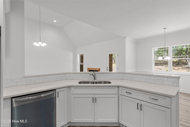 kitchen featuring stainless steel dishwasher, a sink, a chandelier, decorative light fixtures, and lofted ceiling