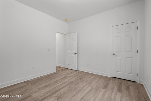 unfurnished bedroom with wood finished floors and baseboards