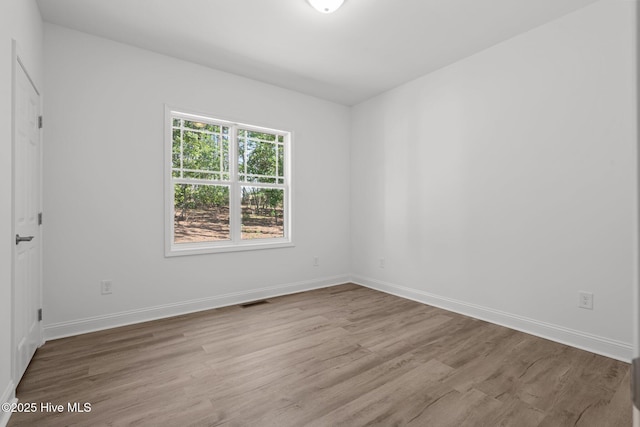 spare room featuring wood finished floors and baseboards
