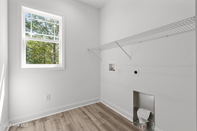 laundry room featuring electric dryer hookup, washer hookup, wood finished floors, and baseboards