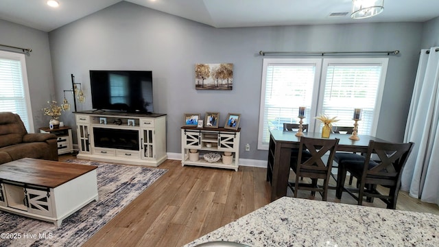 living area featuring wood finished floors, plenty of natural light, baseboards, lofted ceiling, and recessed lighting