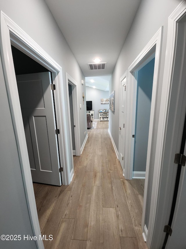 hall featuring hardwood / wood-style flooring and baseboards