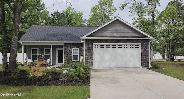 view of front facade featuring a garage, covered porch, concrete driveway, stone siding, and a front yard