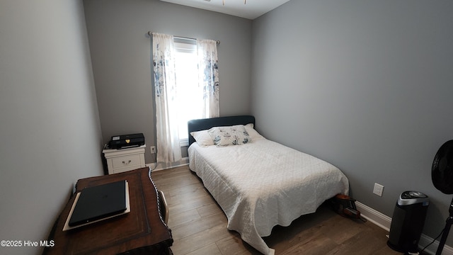 bedroom featuring wood finished floors and baseboards