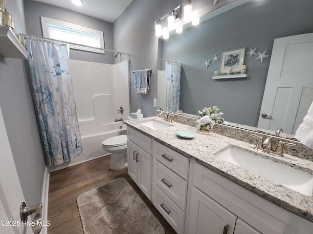 full bathroom featuring wood finished floors, shower / tub combo, toilet, and double vanity