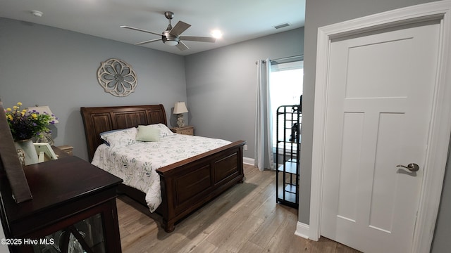 bedroom with light wood-style floors, baseboards, and ceiling fan