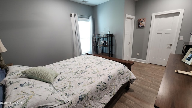 bedroom featuring wood finished floors and baseboards