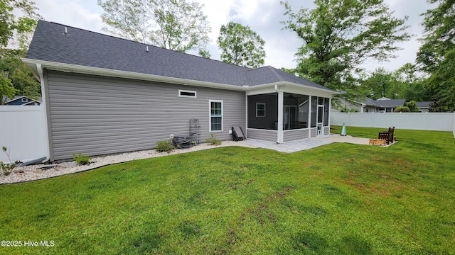 back of property featuring a sunroom, a patio area, a shingled roof, and ceiling fan