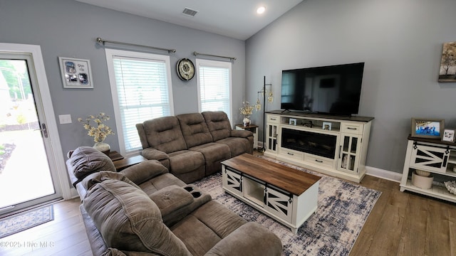 living room with wood-type flooring, vaulted ceiling, healthy amount of natural light, baseboards, and recessed lighting