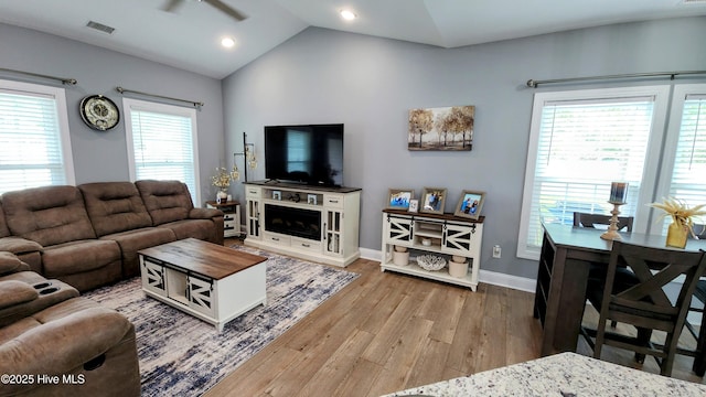 living room featuring light wood finished floors, vaulted ceiling, baseboards, and recessed lighting