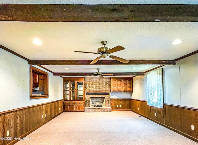 434 Farless Rd, Merry Hill, NC 27957 - unfurnished living room featuring a wainscoted wall, beamed ceiling, a ceiling fan, wooden walls, and carpet floors